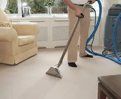 Carpet cleaning professional removing dirt and stains with a hot-water extraction tool in a home, Springfield, MO.